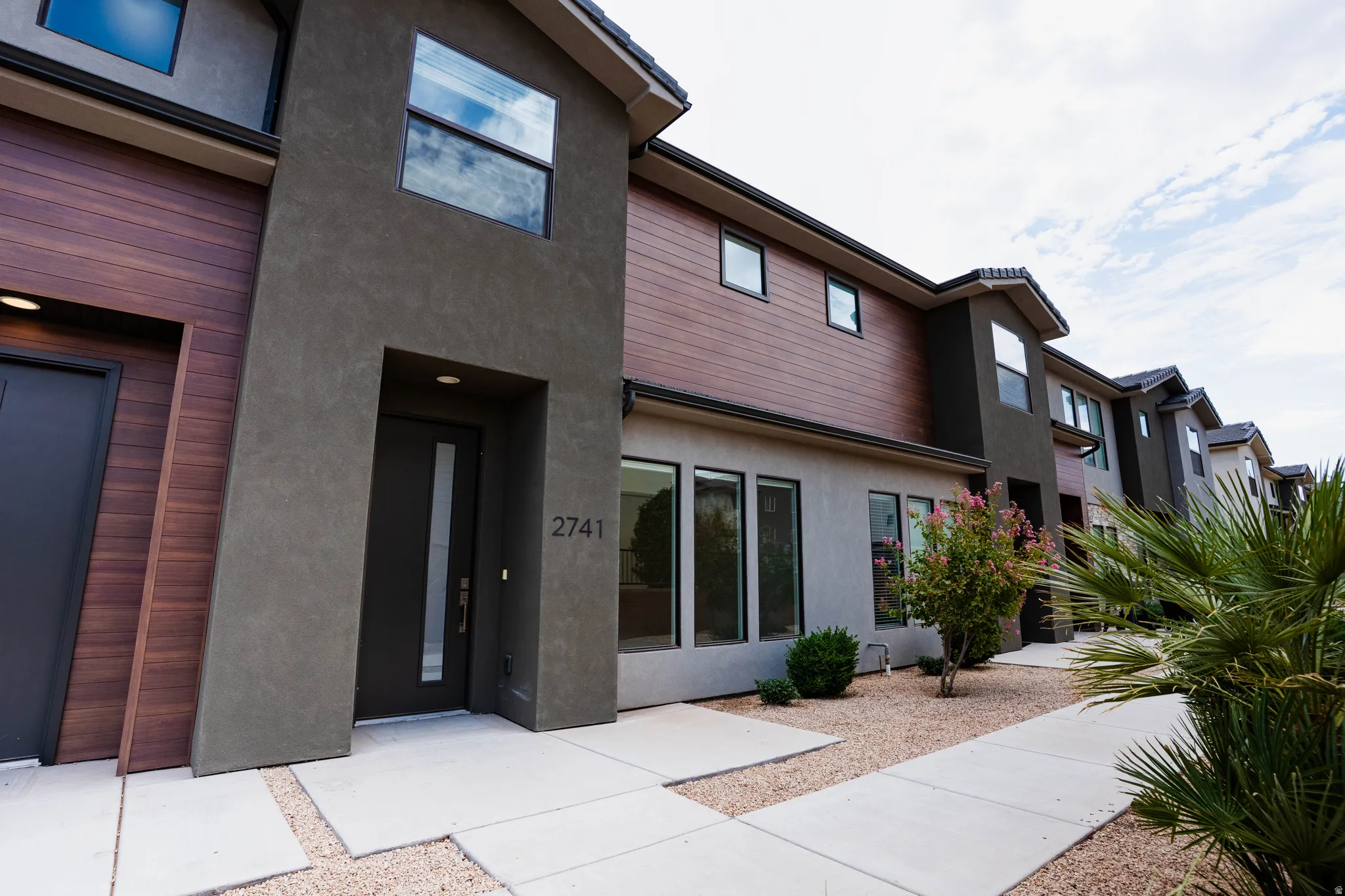 Contemporary exterior featuring dark stucco and wood-finish siding