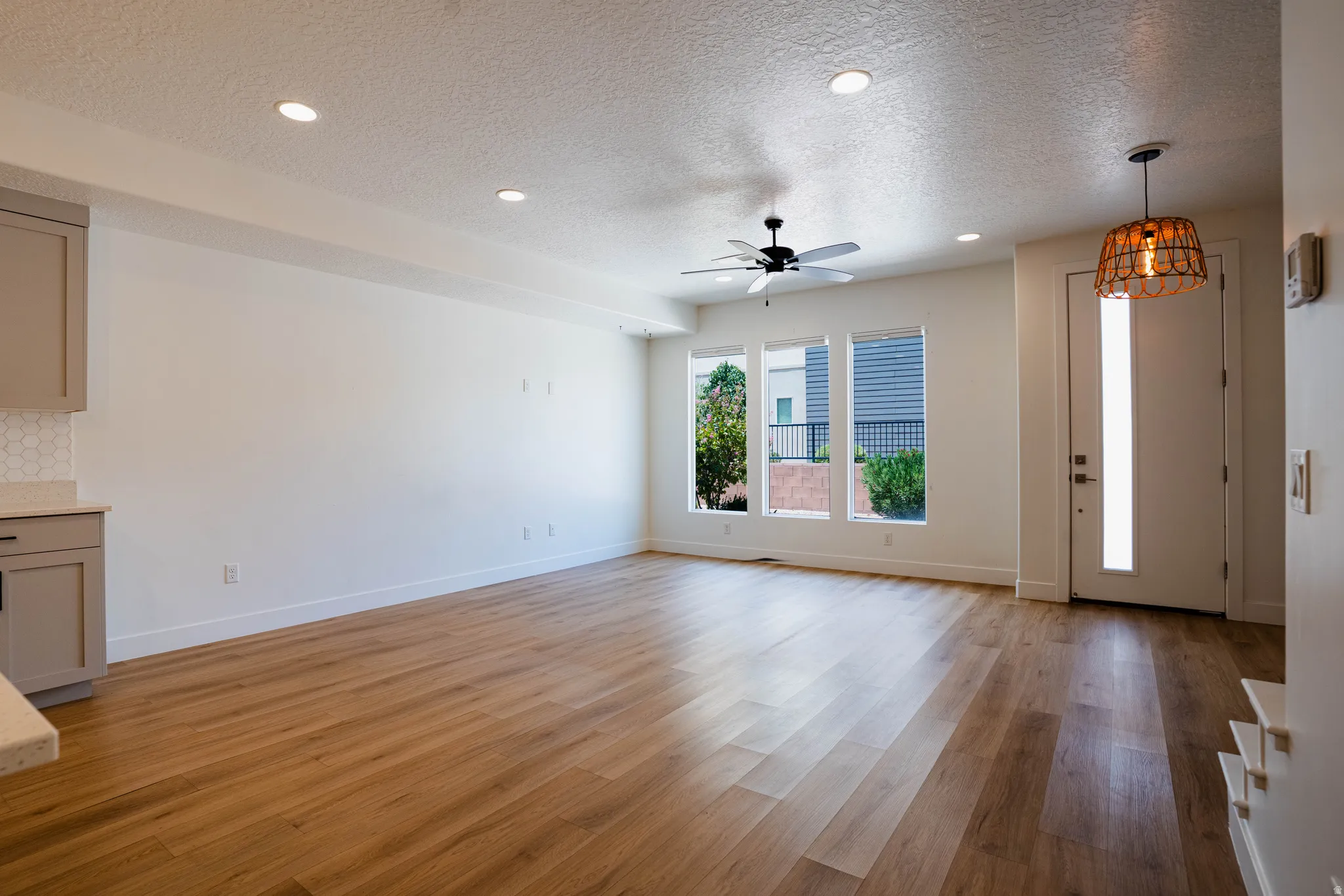 Open-concept living area featuring wood-finish flooring, recessed lighting, and a ceiling fan