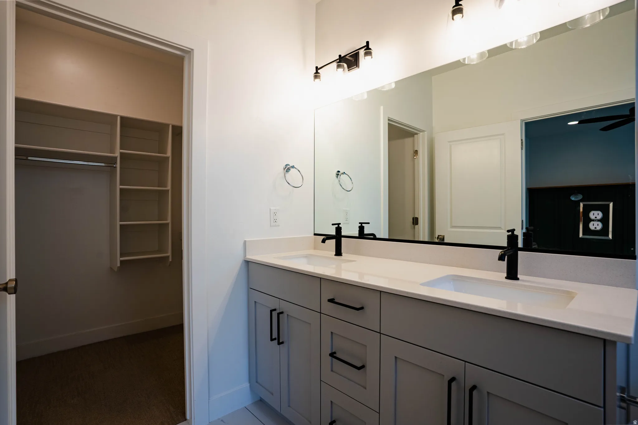 Double vanity featuring undermount sinks, light-toned countertops, and matte black fixtures