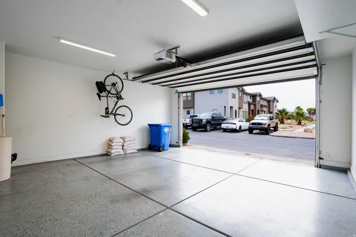 Integrated two-car garage featuring an automatic overhead door, concrete flooring, and built-in overhead lighting