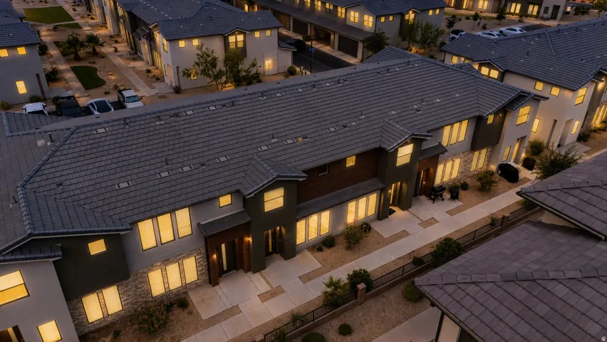 Modern multi-level townhome featuring a tile roof, stone accent facade, and large windows
