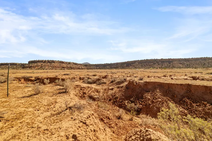 Expansive desert landscape featuring natural terrain and distant rock formations