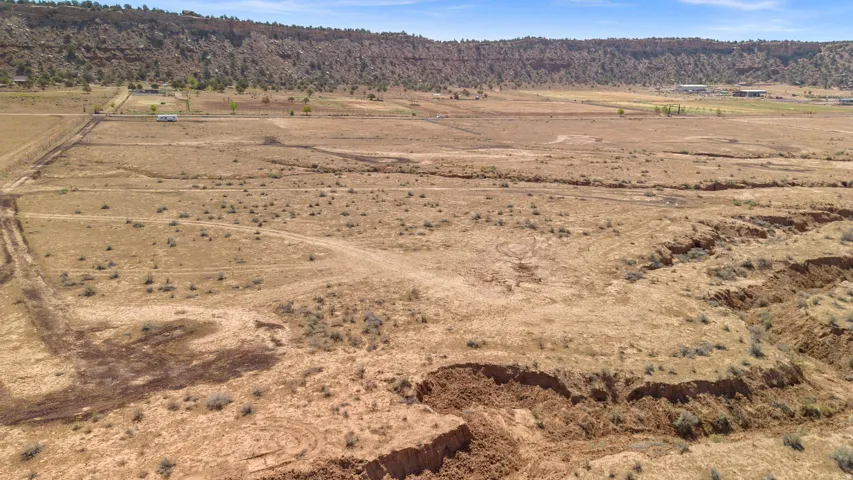 Expansive arid landscape featuring natural terrain and distant mountainous backdrop