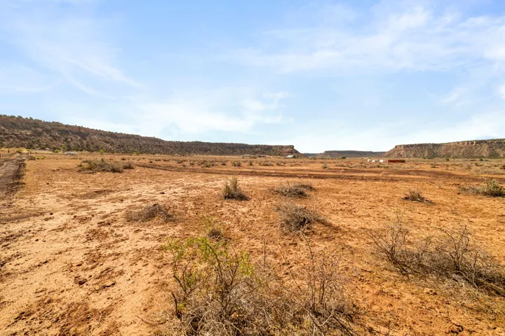 Expansive desert landscape featuring natural terrain and distant mesa formations