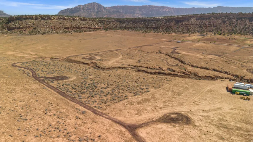 Expansive desert landscape featuring natural terrain and distant mountainous backdrop