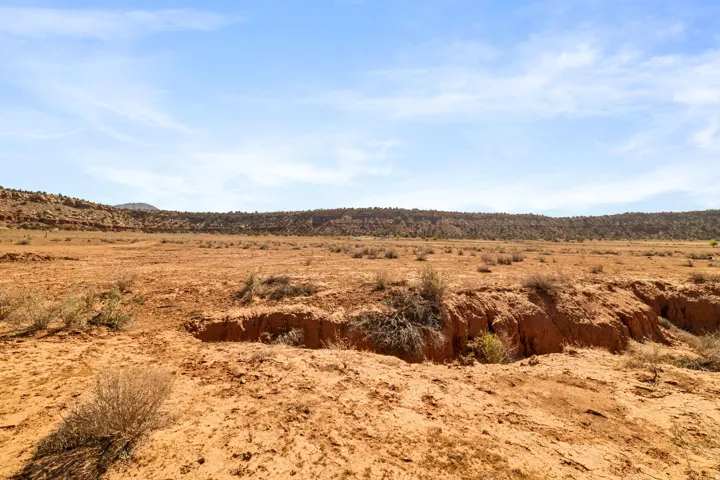 Expansive arid landscape featuring natural terrain and distant elevated landforms