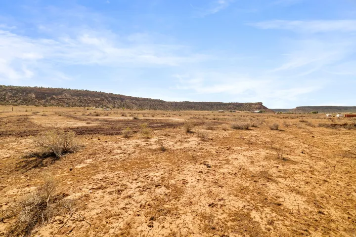 Expansive undeveloped land featuring diverse terrain and distant mesa formations