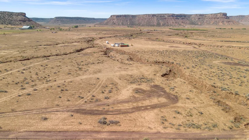 Expansive rural property featuring a vast open landscape and distant mesa formations
