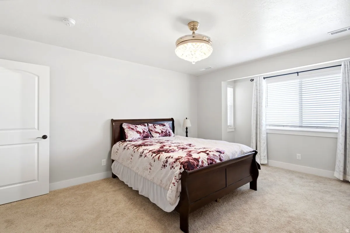 Carpeted bedroom with a decorative ceiling light fixture
