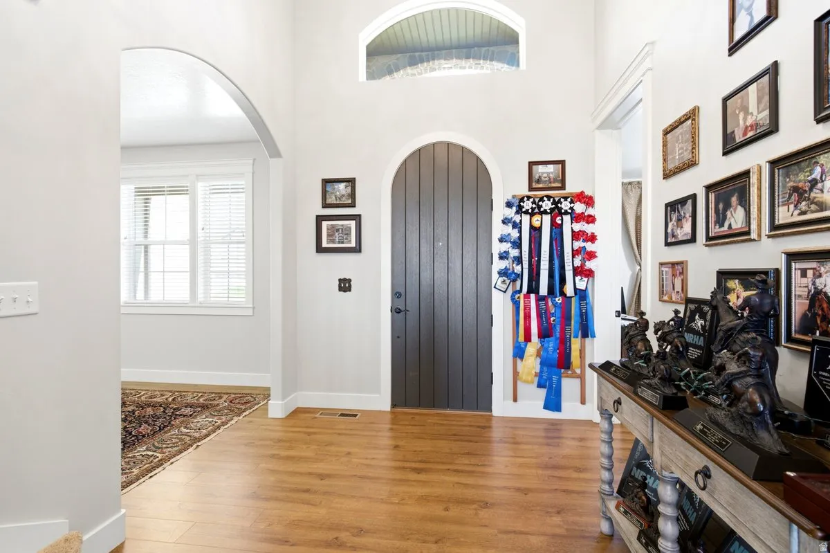 Arched front door with a high transom window, complemented by wood-finish flooring