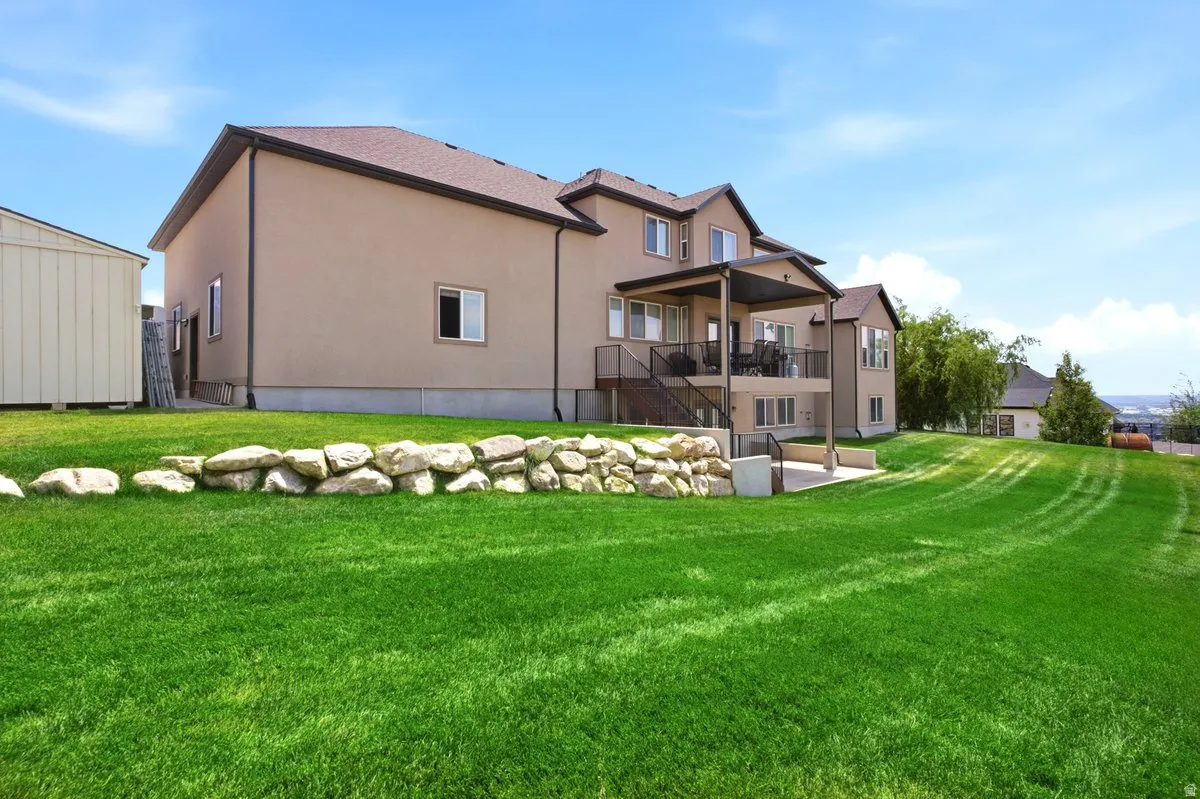 Expansive sloped lawn with a rock retaining wall