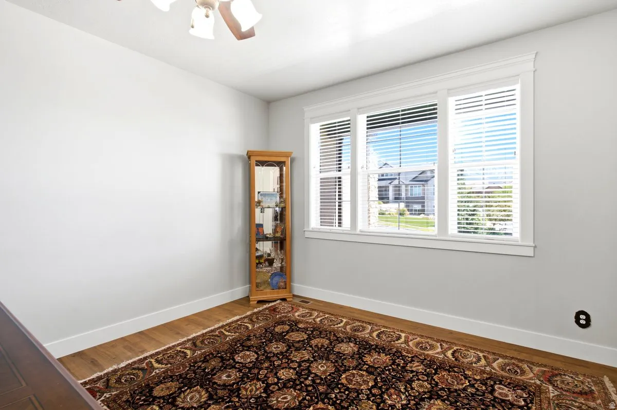 Room with light grey walls, white trim, and wood-finish flooring