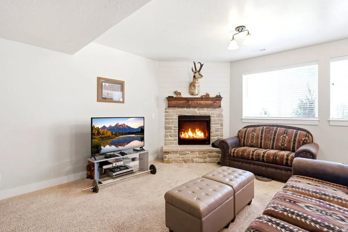 Corner fireplace featuring a stone surround and wood mantel