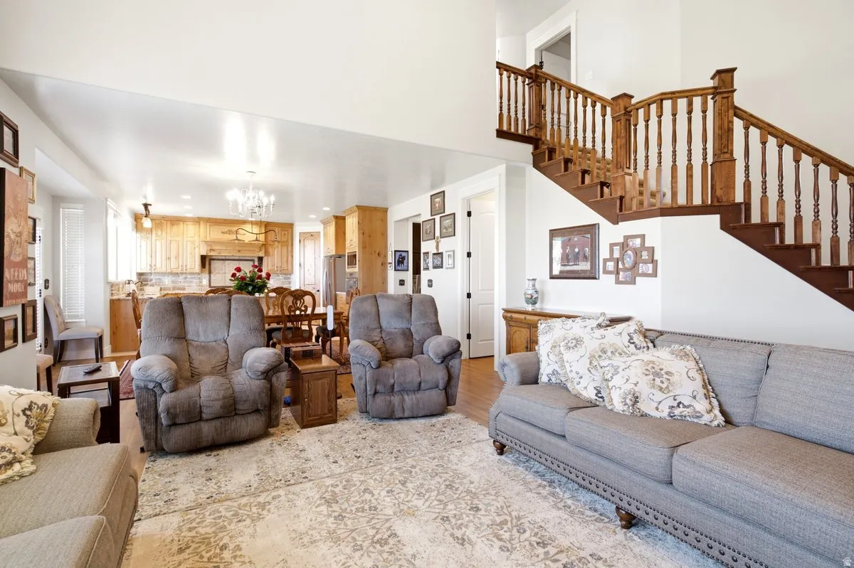 Open-concept living space featuring a wood staircase, light wood kitchen cabinetry, and light wood flooring