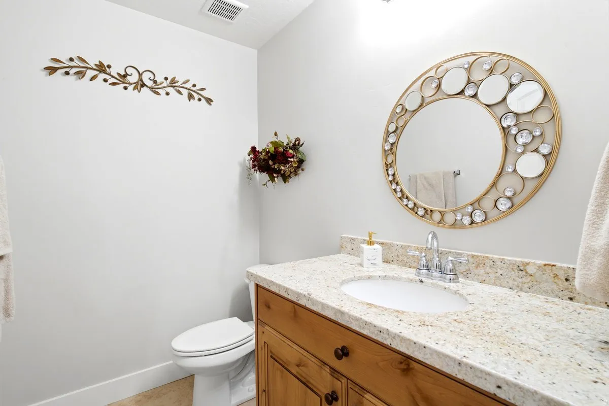 Bathroom vanity with a granite countertop, integrated sink, and chrome faucet