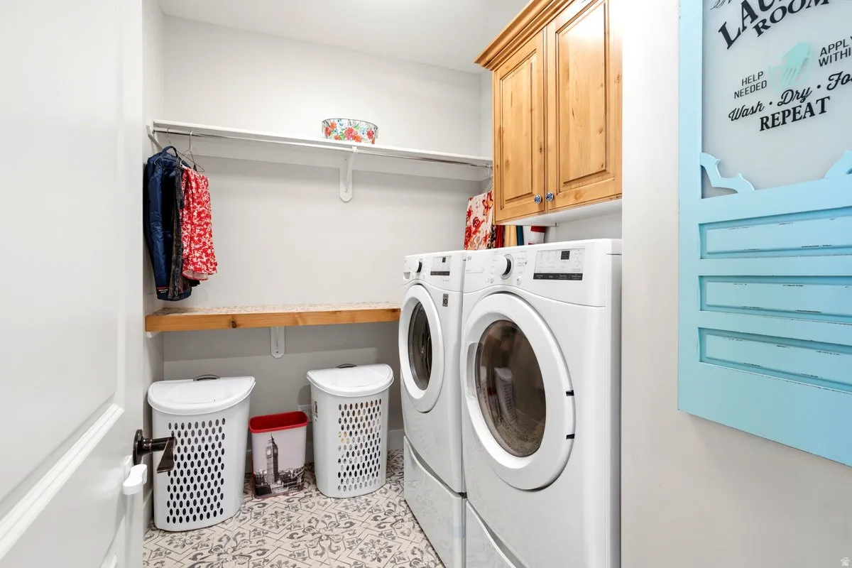 Laundry area featuring patterned tile flooring and light-toned walls