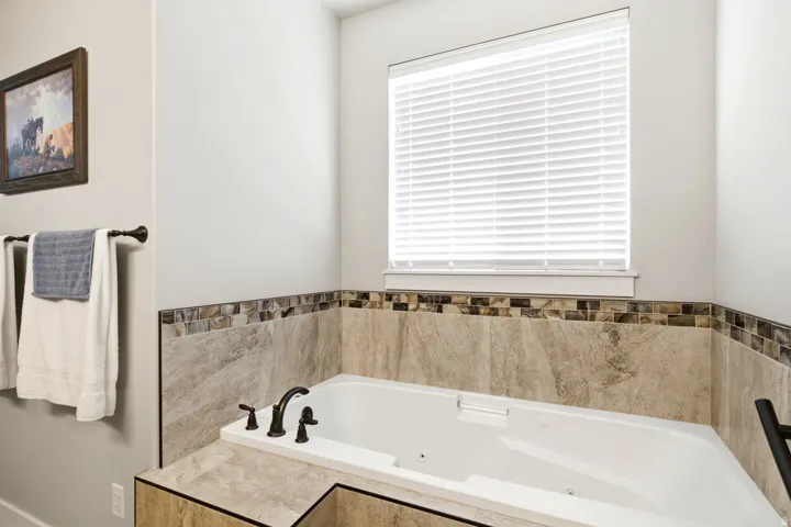 White built-in soaking tub with dark bronze fixtures