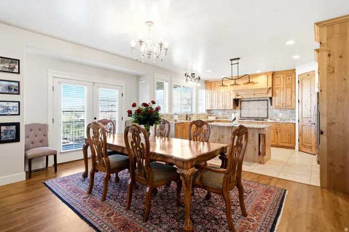 Open-concept living space featuring wood-finish flooring, a kitchen with light wood cabinetry, a central island, and a tiled backsplash