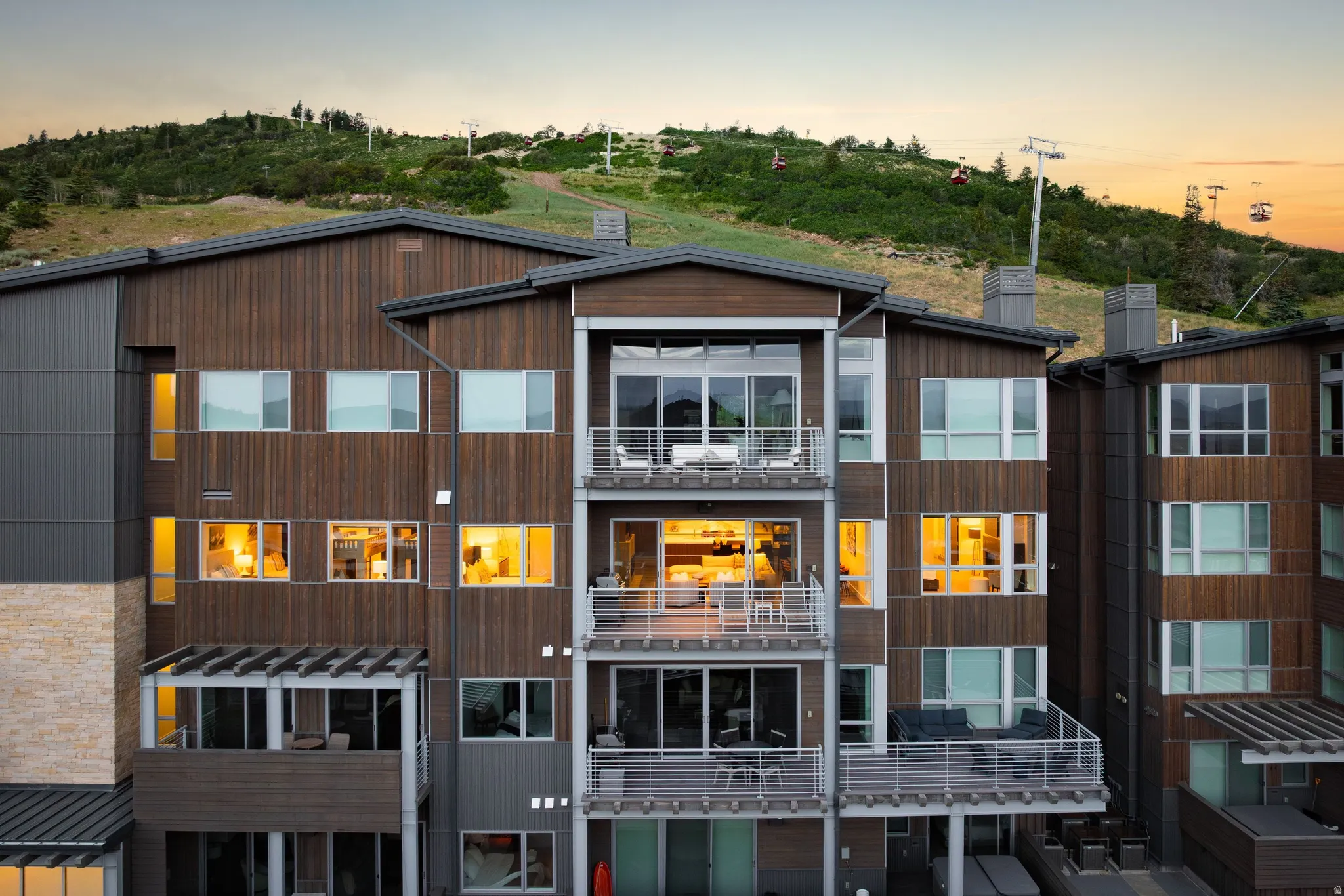 Multi-level architectural facade featuring extensive wood-finish siding and prominent balconies with metal railings