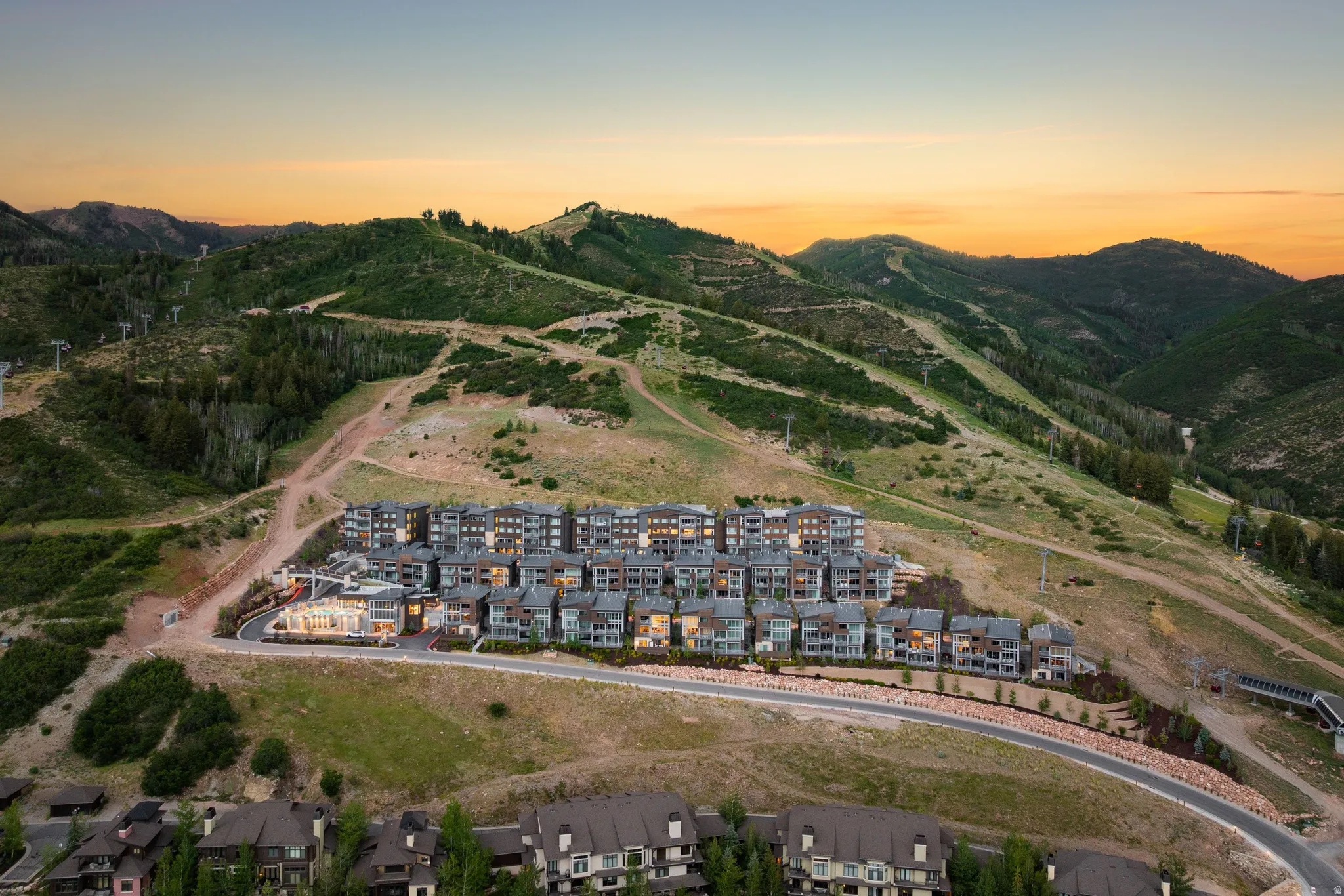Modern multi-story residences nestled into a lush, mountainous landscape