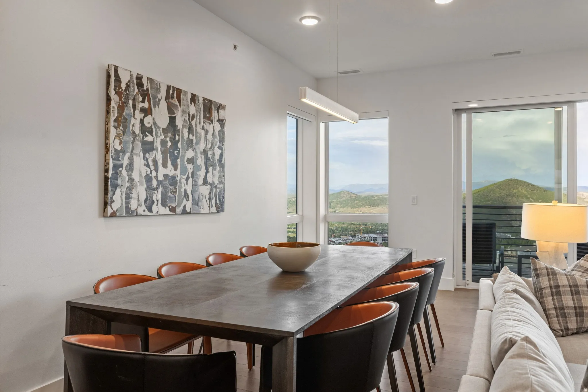 Open-concept dining area with large format sliding glass doors, recessed lighting, and wood-finish flooring