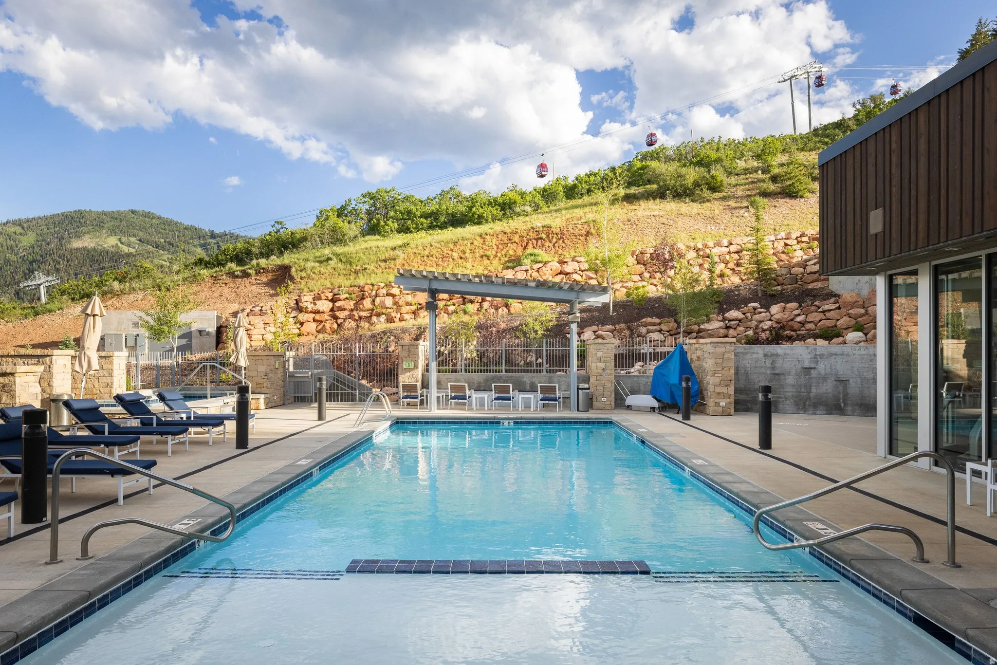 Outdoor swimming pool with integrated spa and mountain backdrop