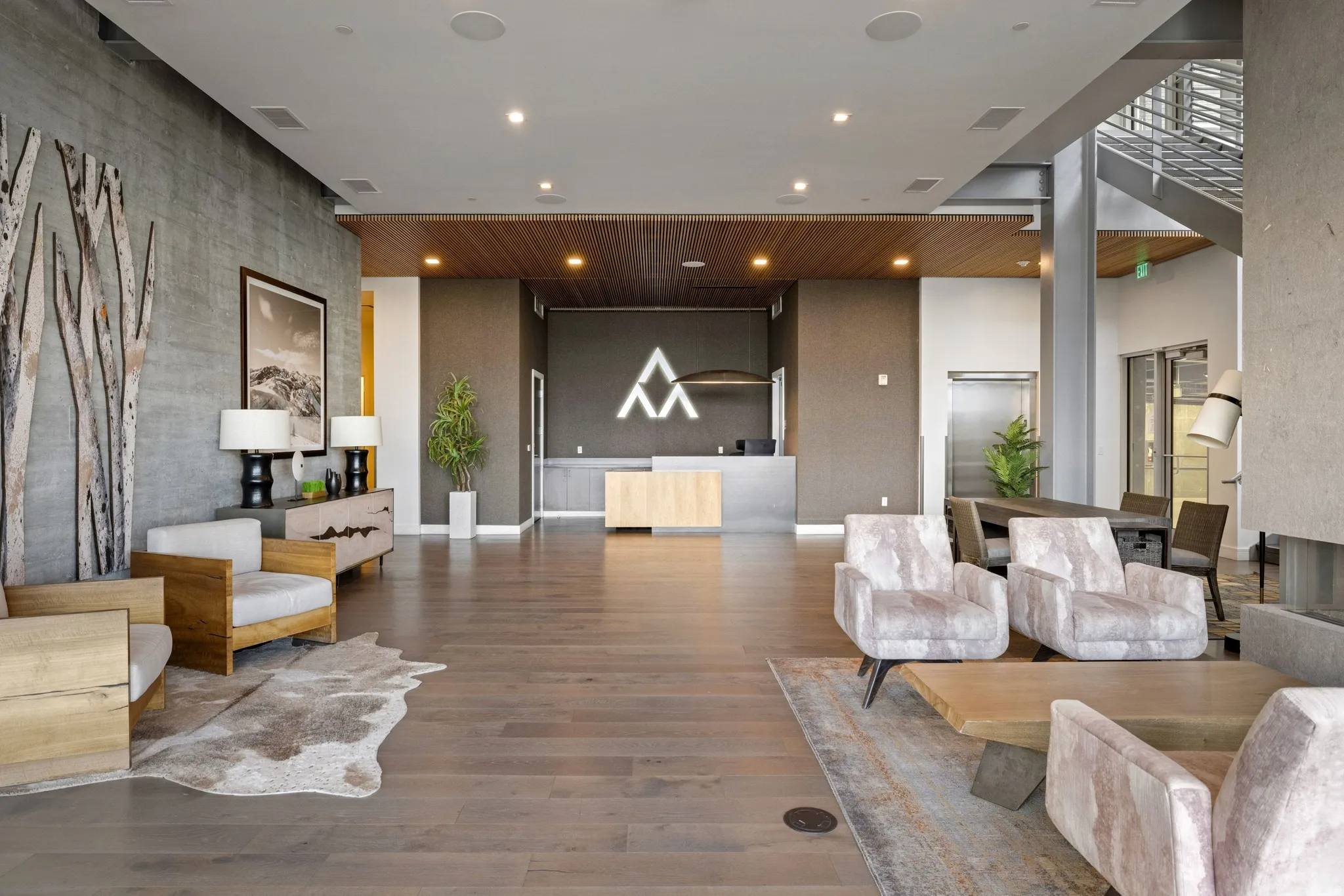 Spacious common area featuring wood-finish flooring, a wood panel ceiling accent, and a prominent reception desk
