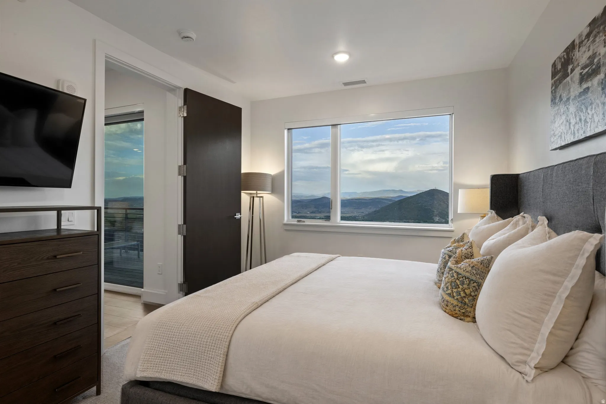 Bedroom featuring a large window with distant mountain scenery