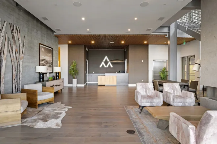 Spacious common area featuring wood-finish flooring, a wood panel ceiling accent, and a prominent reception desk