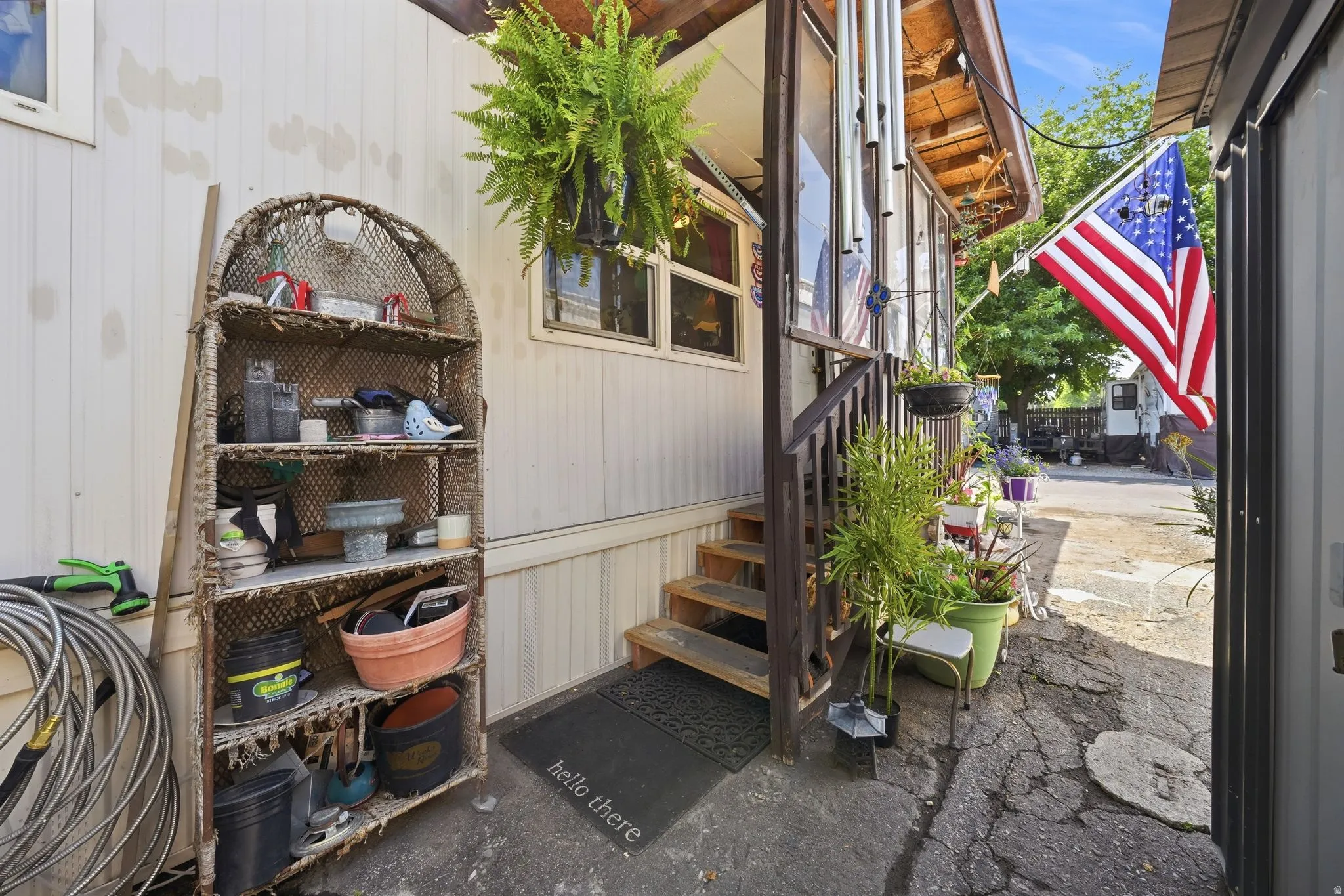 Entryway featuring wood steps and railing, with a white vertical siding exterior