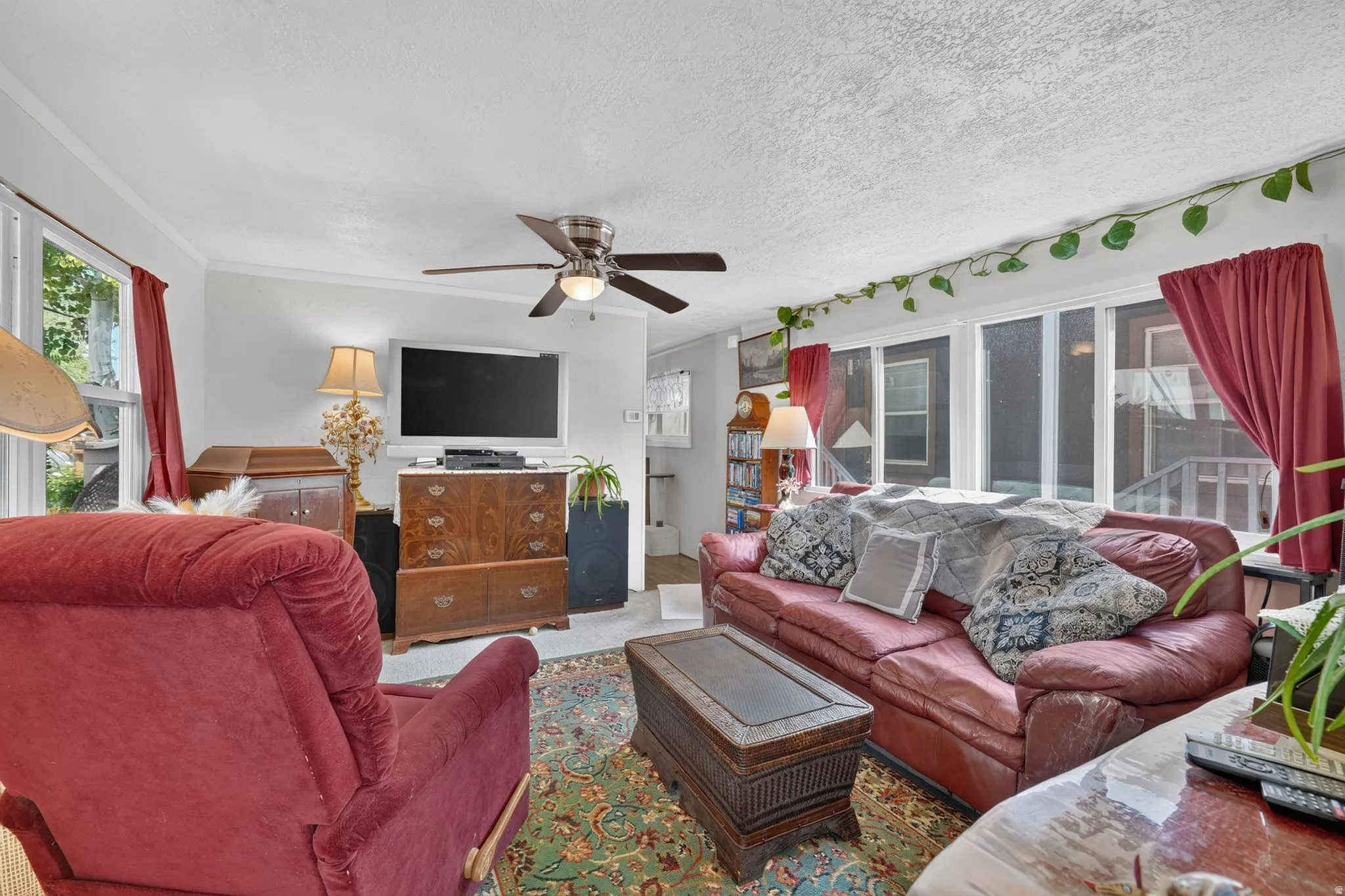 Bright living space featuring a ceiling fan with integrated lighting
