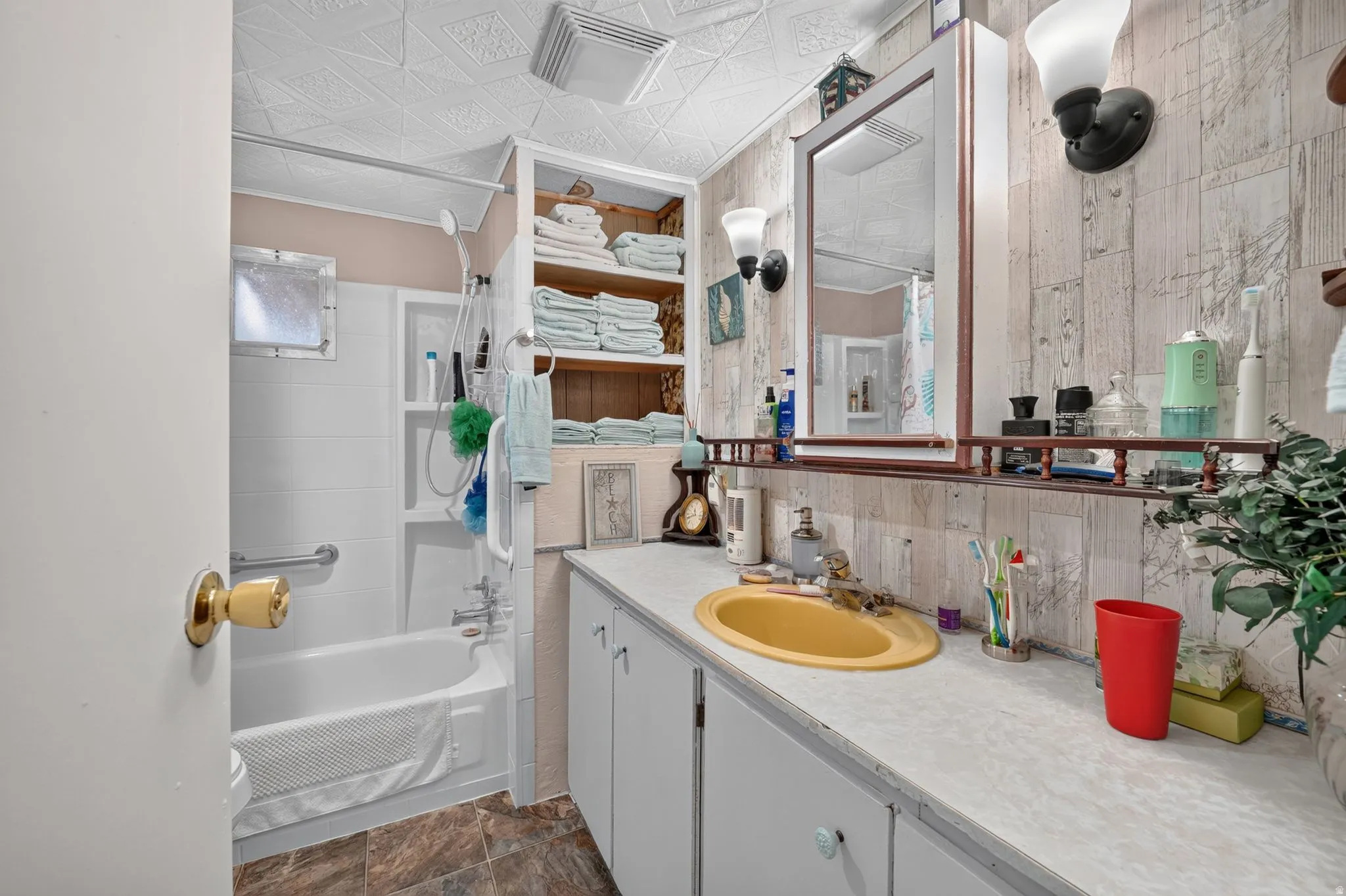 Bathroom featuring a white bathtub, a vanity with a yellow sink, and a mirrored medicine cabinet