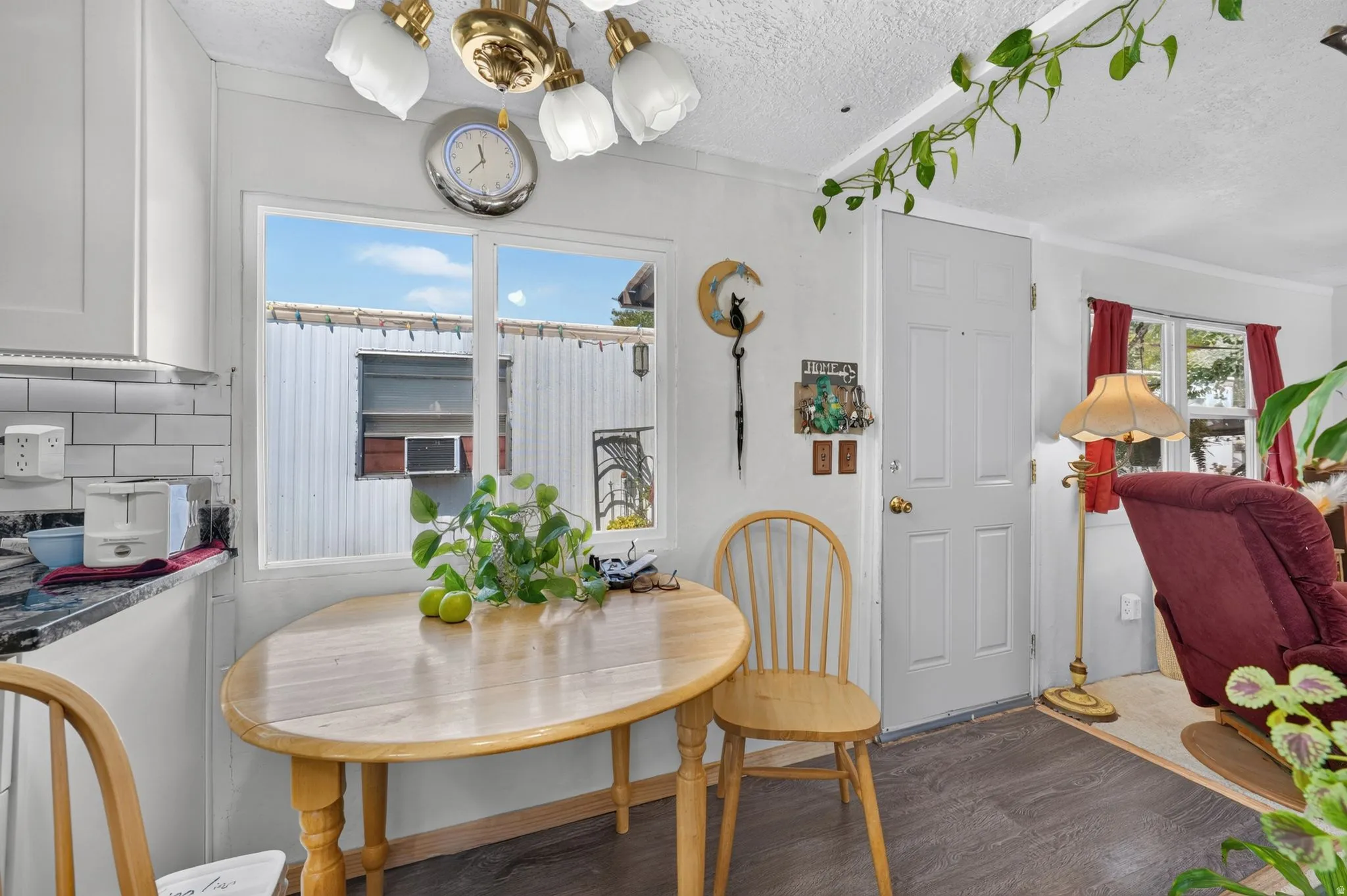 Kitchen area featuring white cabinetry, subway tile backsplash, and a dark stone countertop