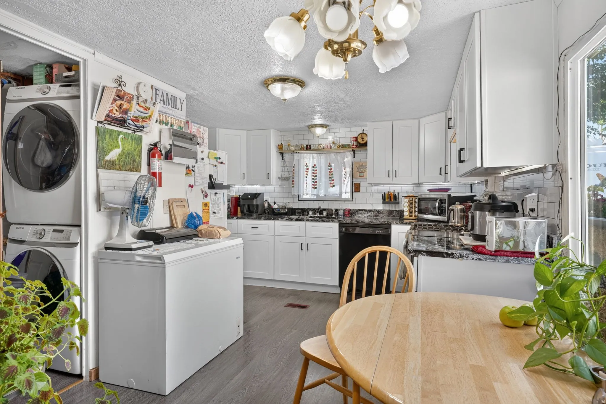 Kitchen featuring white cabinetry, gray subway tile backsplash, and dark countertops