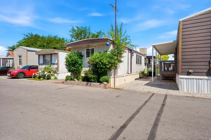 Manufactured home featuring white siding, brown trim, and a gravel perimeter