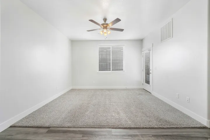 Spacious room with light gray carpet and white baseboards
