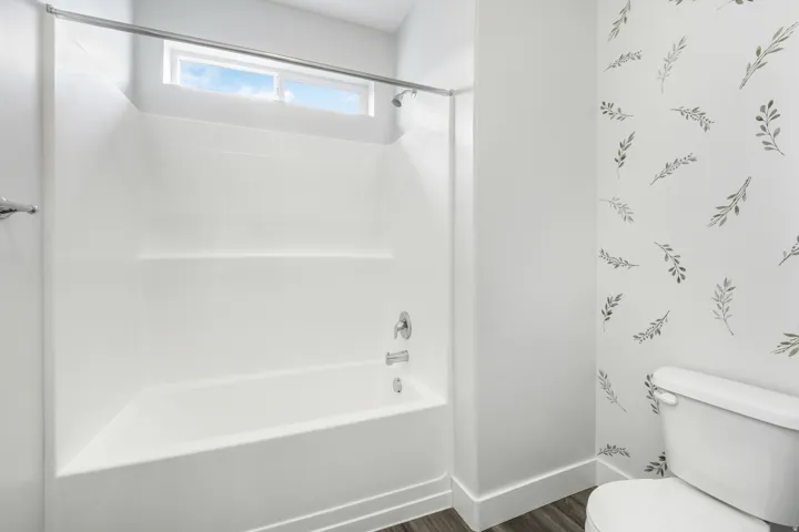 Tub/shower combination featuring a chrome shower rod and fixtures