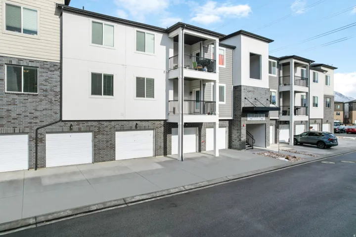 Contemporary multi-story building featuring a mix of white siding, gray siding, and gray brick veneer