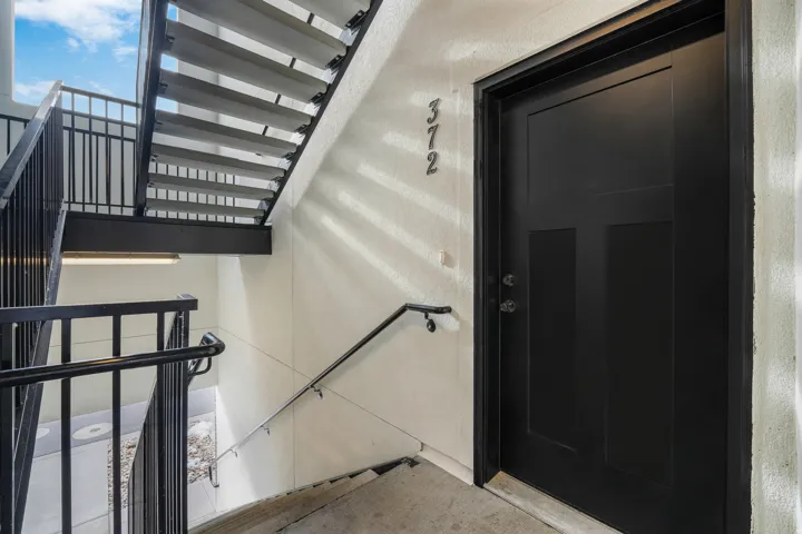 Exterior entryway featuring a modern black door with panel details and matte hardware