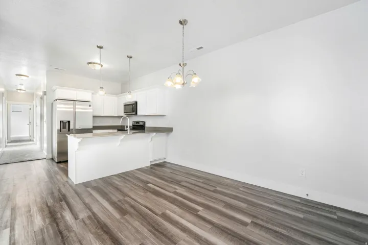 Modern kitchen featuring stainless steel appliances, white cabinetry, and a central island with a sink