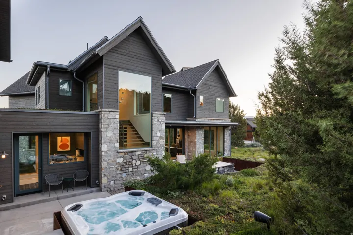Contemporary exterior featuring dark wood siding and extensive stone accents