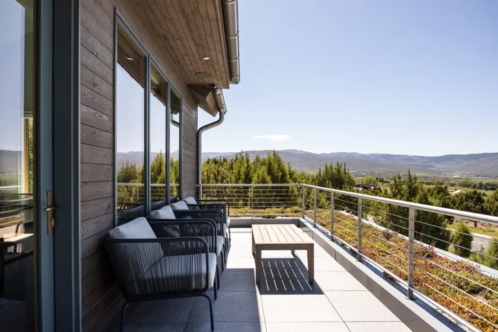 Exterior balcony featuring expansive mountain and valley scenery, a cable railing system, wood-finish siding, and a wood-finish soffit with recessed lighting