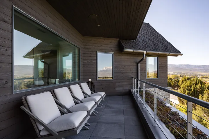 Expansive outdoor balcony featuring dark plank siding and a durable tile surface