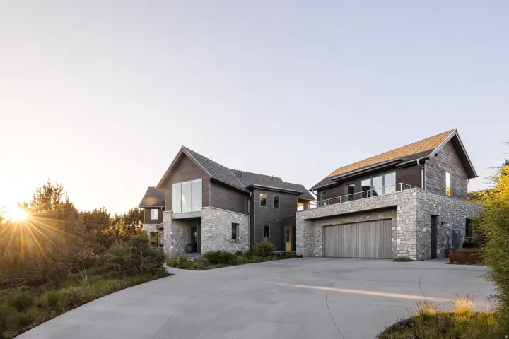 Contemporary exterior showcasing stone veneer and dark wood siding