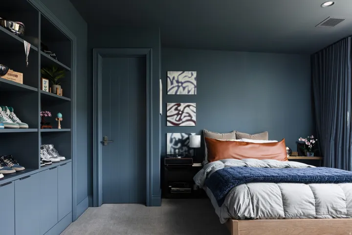 Bedroom featuring built-in shelving with lower cabinetry, a paneled door, and recessed lighting