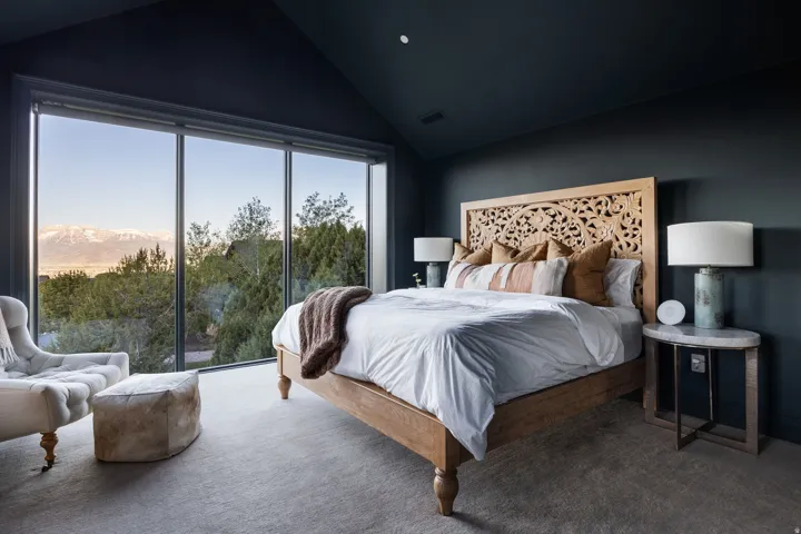 Expansive floor-to-ceiling windows with mountain and tree-lined scenery