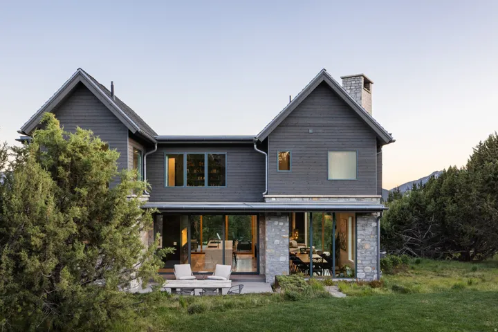 Contemporary two-story residence with dark siding and stone accents