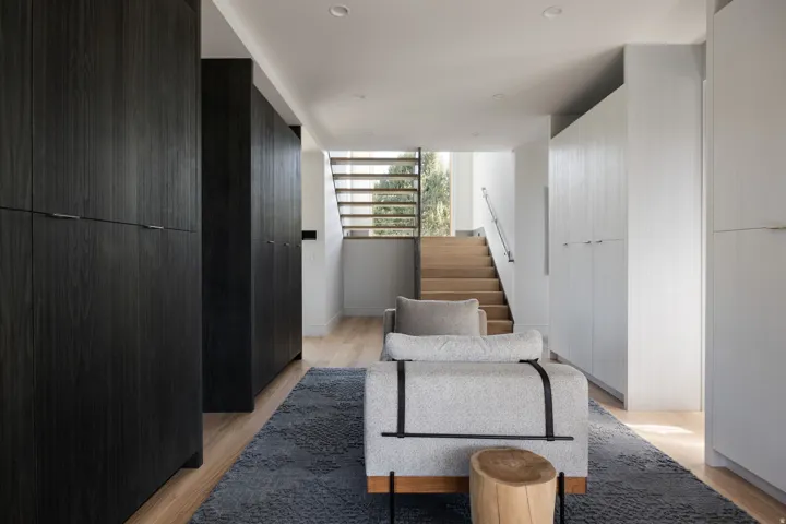Hardwood flooring complements the modern staircase with metal handrail