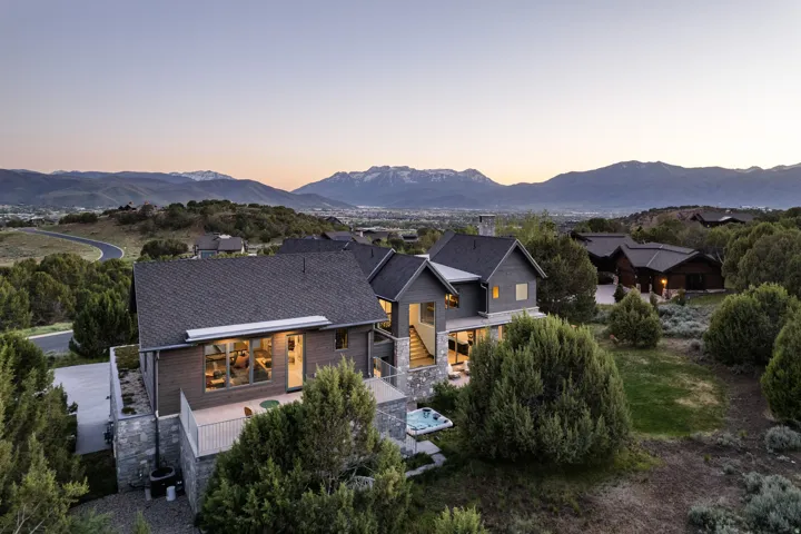 Contemporary multi-level residence featuring dark siding and a stone foundation