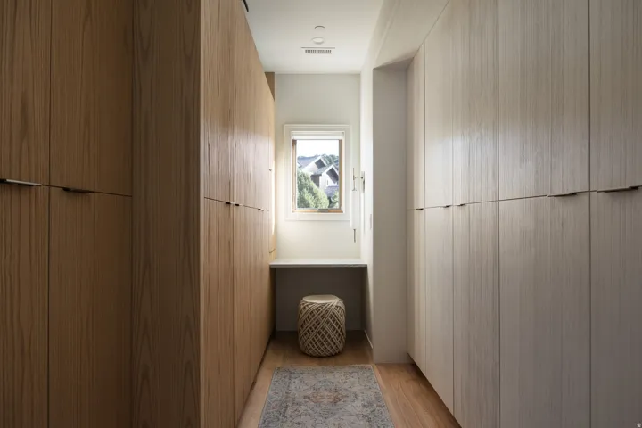 Custom closet system featuring full-height wood-finish cabinetry